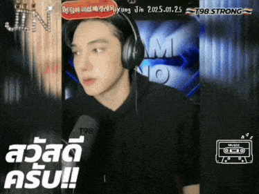 a man wearing headphones and a black shirt with the number t98