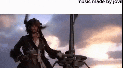 a man in a pirate costume is standing on top of a boat in the ocean .