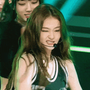 a woman wearing a microphone making a funny face on stage