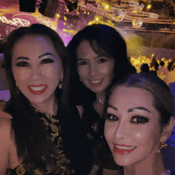three women are posing for a picture and one of them is wearing a black and yellow dress