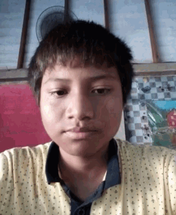 a young boy is making a funny face while wearing a yellow shirt with polka dots .