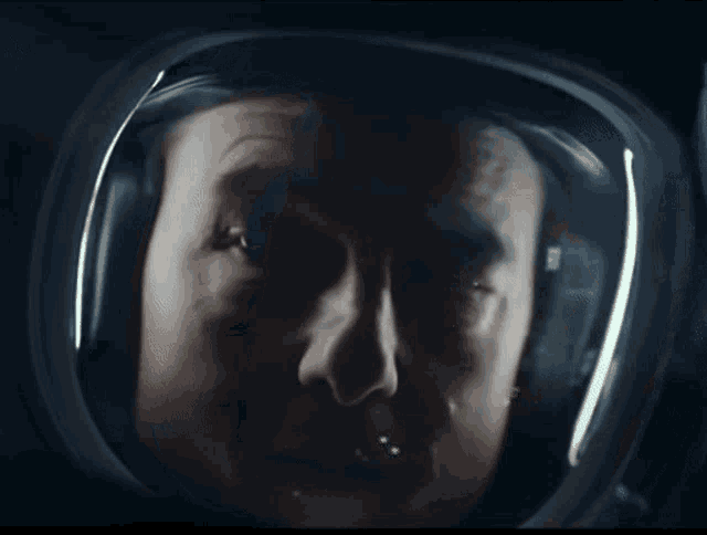 a close up of a man 's face in a helmet