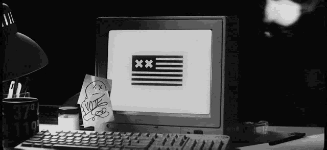 a black and white photo of a computer with a note that says " vote "