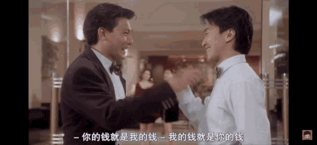 a man in a tuxedo shakes hands with another man