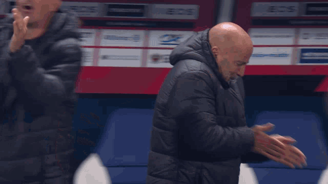 a man without a shirt is being held by another man in a jacket