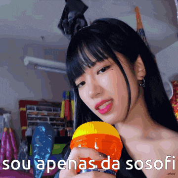 a girl holding a microphone with the words " sou apenas da sosofi " written below her