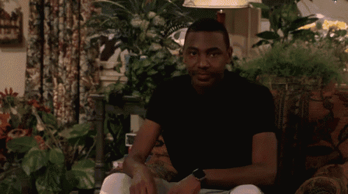 a man in a black shirt is sitting in a chair