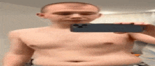 a shirtless man is taking a picture of himself in the mirror with his cell phone .