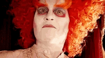 a close up of a person 's face with a red wig .