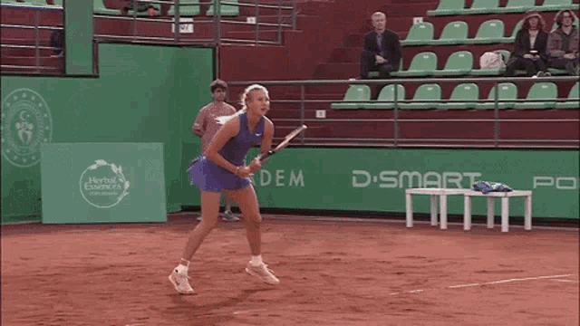 a woman is playing tennis in front of a sign that says d smart