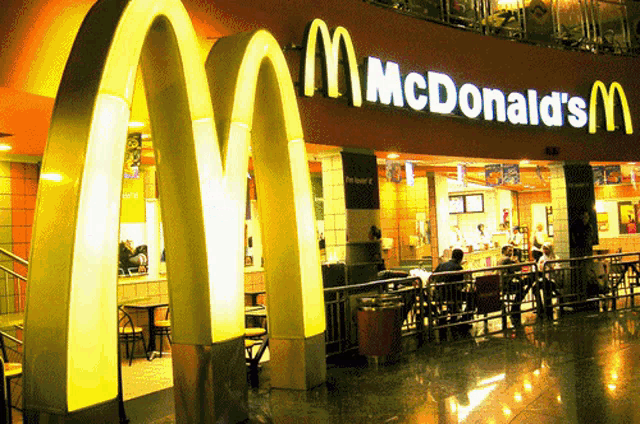 a mcdonald 's restaurant with people sitting at tables