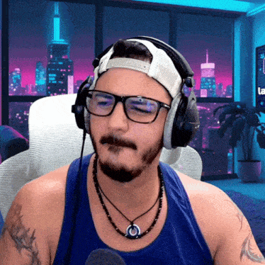 a man wearing headphones and glasses is sitting in front of a computer screen that says la