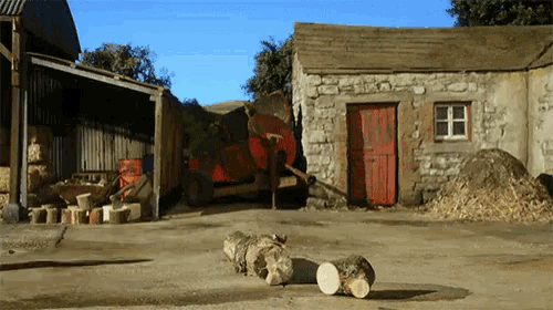 a red truck is parked in front of a stone building with a red door
