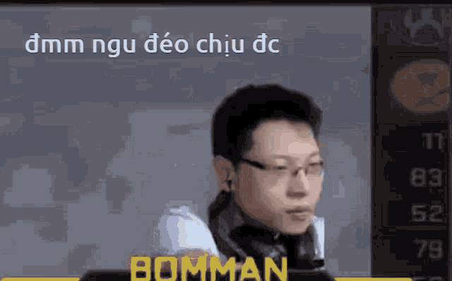 a man wearing glasses and headphones is standing in front of a screen with the word bomman on it