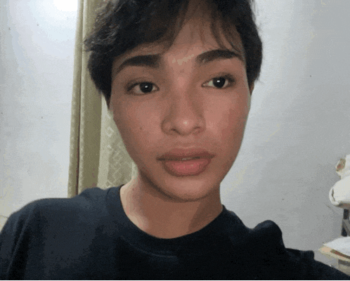 a close up of a person 's face with a black shirt