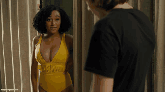 a woman in a yellow swimsuit looks at herself in a mirror