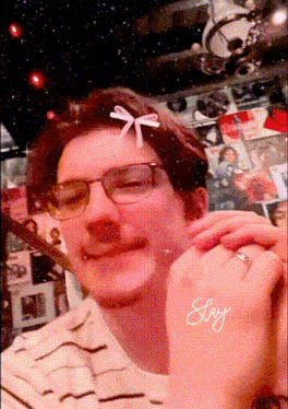 a man wearing glasses and a bow on his head has the word stay written on his hand