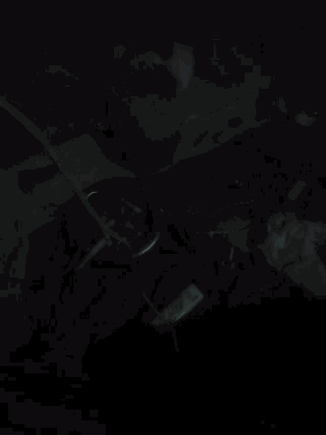 a bunch of wires are laying on the floor in the dark with a red light behind them