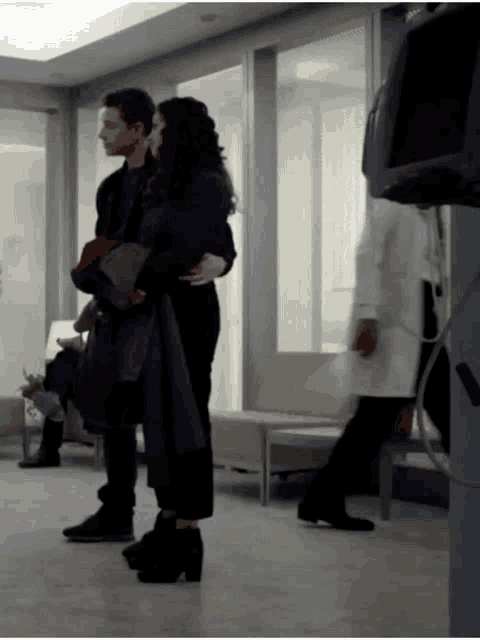 a man and a woman are hugging in a hospital waiting area