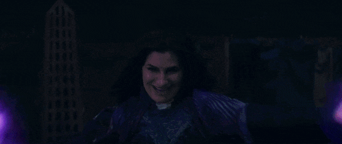 a woman in a purple dress is holding a purple glowing object in her hands .