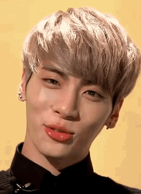 a close up of a person 's face with blonde hair and red lipstick .