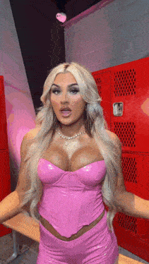 a woman in a pink top and shorts is standing in a locker room .