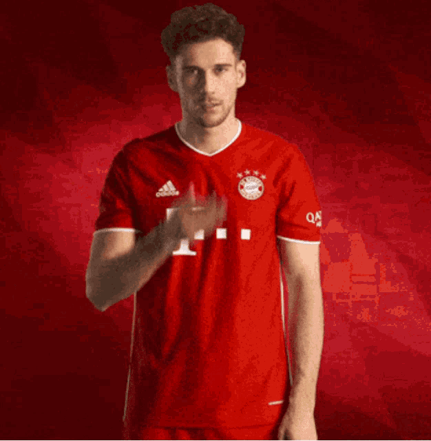 a man wearing a red adidas t-mobile shirt