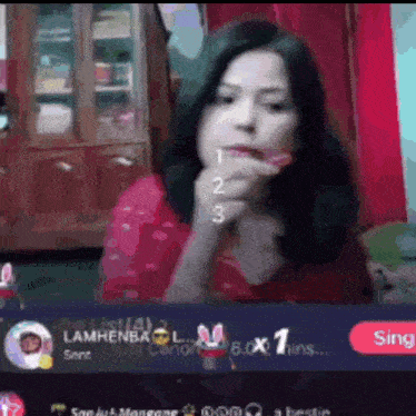 a girl is eating a candy in front of a screen that says ' lambenbaol ' on it