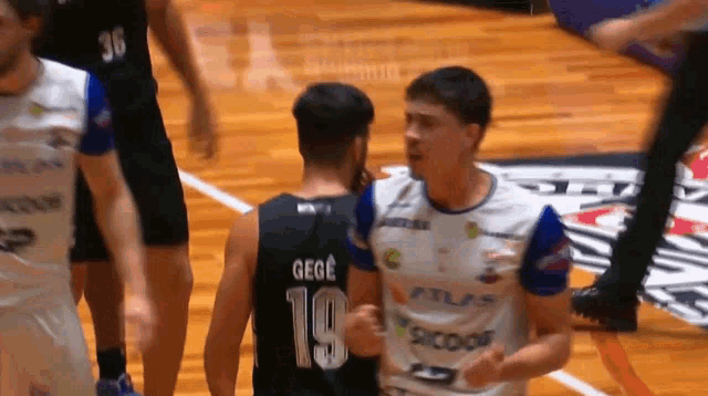 a basketball player wearing a number 19 jersey talks to another player