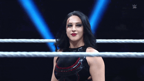 a woman in a wrestling ring with a w logo on the bottom right