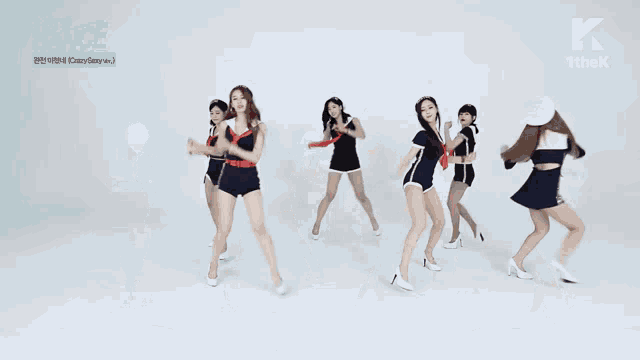 a group of women are dancing in front of a white background with a k on the bottom