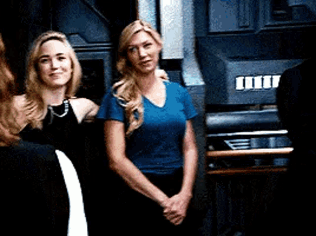 two women are standing next to each other in front of a machine .