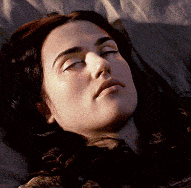 a woman with her eyes closed is laying on a bed