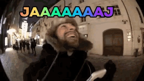 a man is laughing in front of a sign that says jaaaa