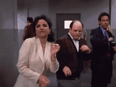 a group of people are dancing in a hallway while a woman looks on .