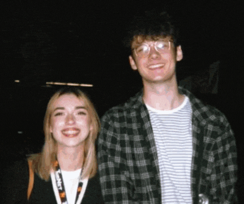 a man and a woman are posing for a picture and the woman has a lanyard around her neck that says ' planet '