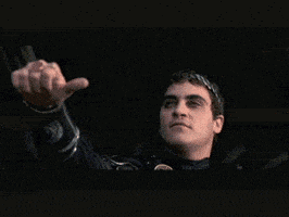 a man giving a thumbs up sign in a dark room