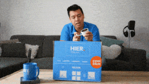 a man sitting on a couch with a box that says hier