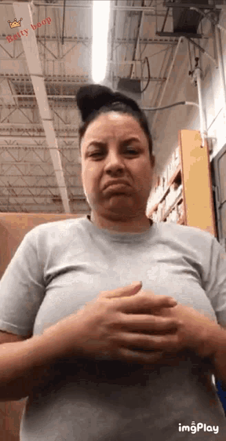 a woman is making a funny face in a store while holding her breasts .