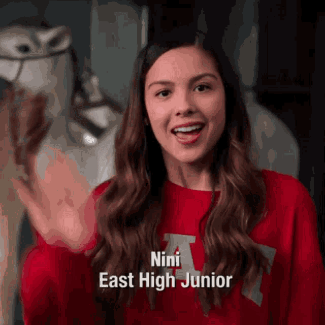 a girl in a red sweater with the name nini east high junior on it