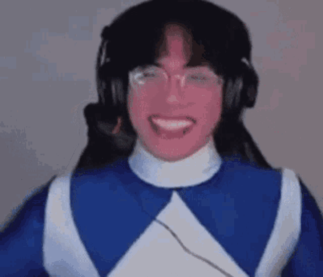 a man in a blue and white power ranger costume is wearing headphones and making a funny face .