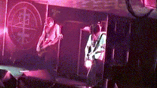 a man is playing a guitar in front of a sign that says jb