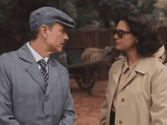 a man and a woman standing next to each other and looking at each other