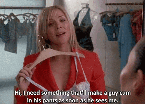 a woman in a red jacket is holding a hanger and talking to a man in a closet ..