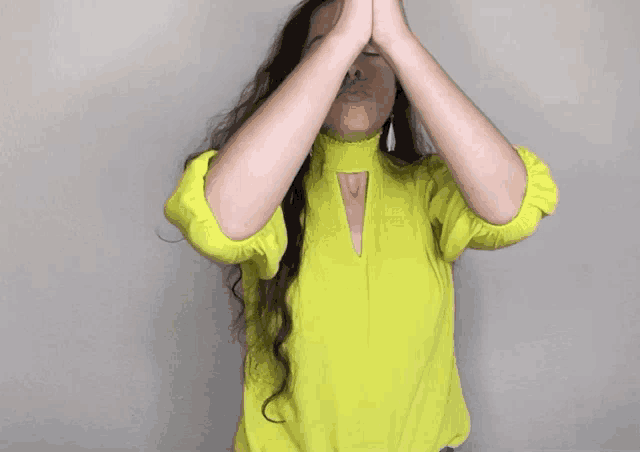 a woman wearing a neon yellow shirt is praying