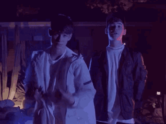 two young men standing next to each other with one wearing a white shirt that says ' abercrombie & fitch ' on it