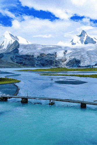a bridge across a body of water with mountains in the background