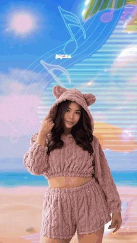 a woman wearing a pink sweater and shorts with cat ears on her hood