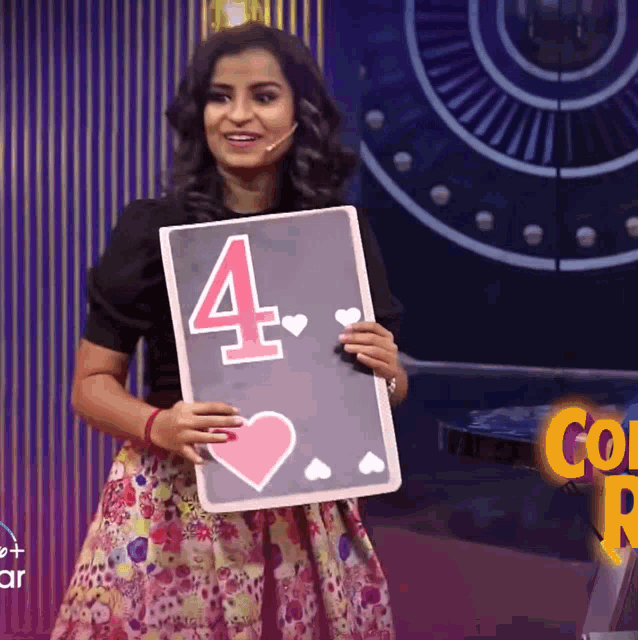 a woman holding a card with the number four on it