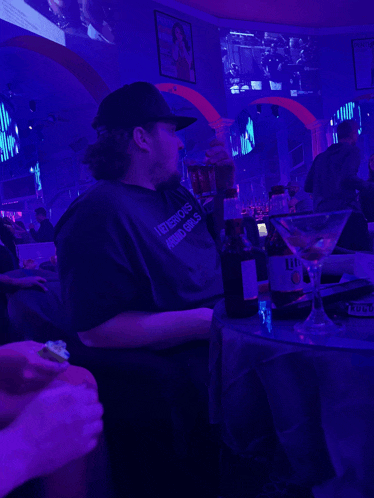 a man wearing a t-shirt that says i love boys and girls sits at a table